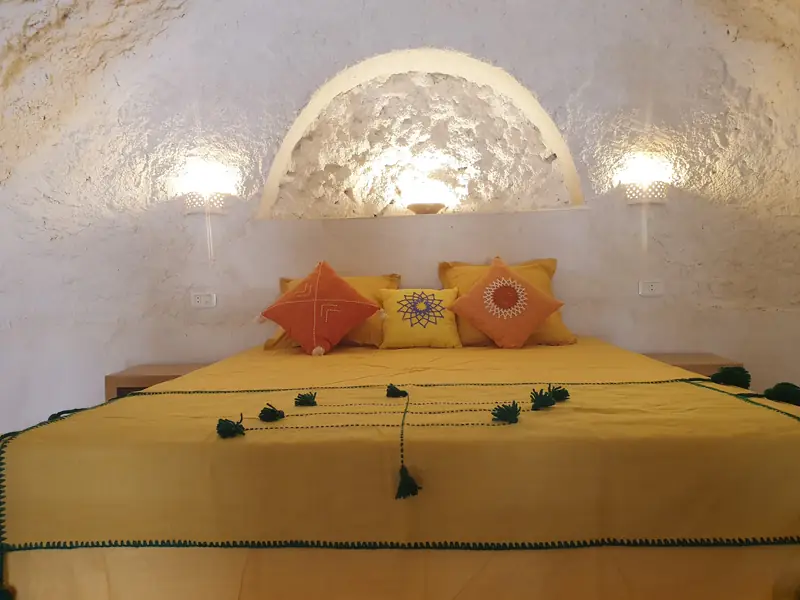 Chambre troglodyte : lit double et coussins brodés
